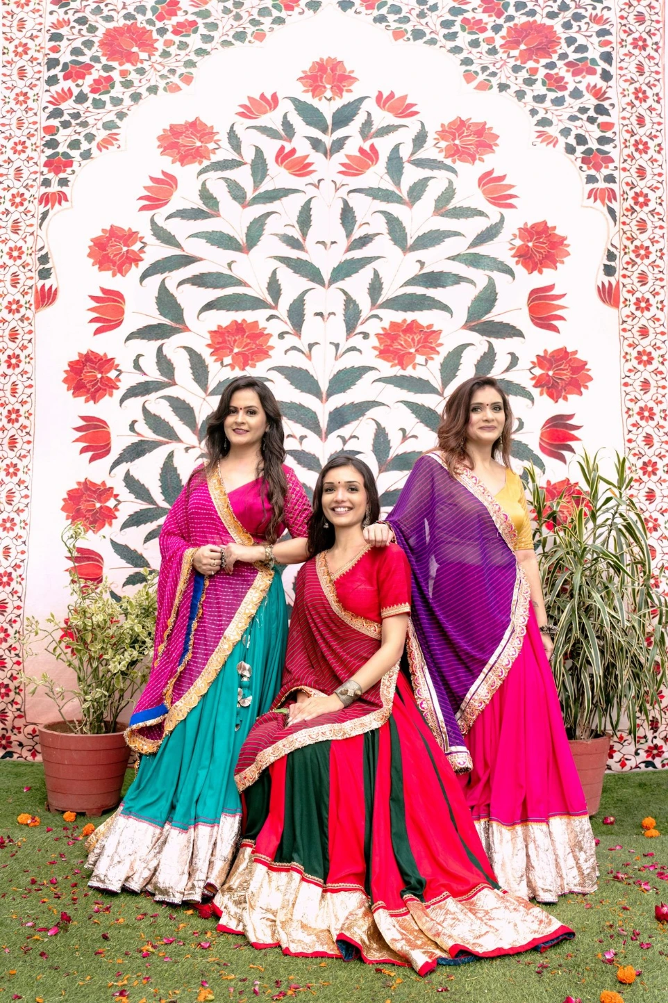 Three women in colorful traditional indian outfits